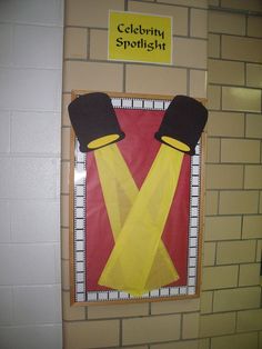 a bulletin board with two hats and suspenders on it's sides, in front of a brick wall