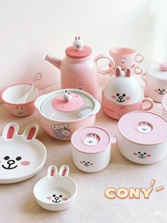 a table topped with dishes and cups filled with bunny themed food containers next to teapots