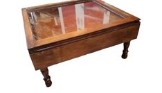 an old wooden table with glass top