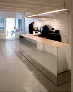 an empty office with two people standing at the counter