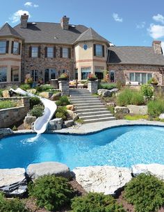 a large house with a swimming pool in the front yard and stairs leading up to it