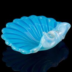 a blue glass bowl sitting on top of a black table next to a white object