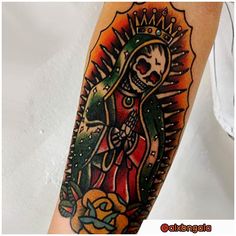 a woman with a skull and roses tattoo on her arm is holding an orange rose