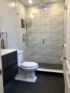 a white toilet sitting next to a walk in shower