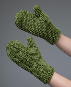 two green knitted mittens sitting on top of each other