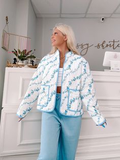 Wrap yourself in floral perfection with the Blue Floral Crest Quilted Jacket from Sassy Shortcake. This ivory, quilted jacket features a playful blue floral pattern and side pockets, all finished off with a blue lined hem. Stay warm and stylish in this fun jacket. content: 100% nylon care: hand wash cold fits true to size, model wearing size small Sassy Shortcake, Fun Jacket, Patriotic Dresses, Cold Fits, Blue Floral Pattern, Blue Quilts, Cool Jackets, Blue Jacket, Quilted Jacket