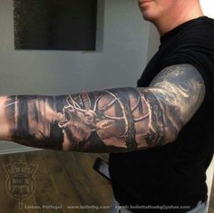 a man with a tattoo on his arm that has deer and trees in the background