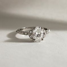 an oval diamond ring with three diamonds on the side