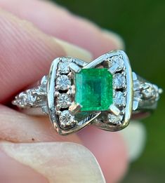 Elevate your jewelry collection with this very unique Vintage Emerald and Diamond Art Deco Style Ring--an exquisite fusion of timeless elegance and Art Deco glamour. This ring is a testament to the opulence of a bygone era, featuring a lush emerald at its center, surrounded by a dazzling array of diamonds, all set in a meticulously crafted Art Deco-inspired design.  Natural emerald weighing .44 carats Natural Diamonds weighing .15 carats.  Size: 6.5 The emerald, with its rich green hue, is a captivating focal point, symbolizing renewal and prosperity. Surrounding this vibrant gemstone are carefully arranged diamonds, adding brilliance and sophistication to the piece. The geometric patterns and intricate detailing of the Art Deco style setting enhance the ring's vintage allure, making it a Luxury Platinum Cluster Emerald Ring, Gia Certified White Gold Emerald Cluster Ring, Gia Certified Diamond Rings For Collectors, Gia Certified Platinum Collectible Rings, Luxury Emerald Cluster Ring With Vvs Clarity, Exquisite Platinum Emerald Ring With Brilliant Cut, Gia Certified Classic Emerald Ring, Heirloom Gia Certified Diamond Ring, Platinum Emerald Ring In White Gold