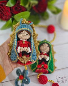 a crocheted doll is held in the palm of someone's hand next to flowers