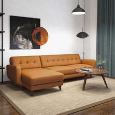 an orange couch sitting on top of a rug in a living room next to a coffee table