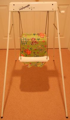 a baby swing in the corner of a room