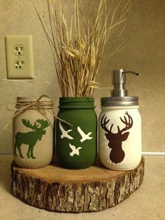 three mason jars with deer and moose decals on them