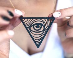 a woman holding up a triangle with an eye on it