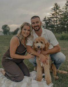 a man and woman pose for a photo with their dog