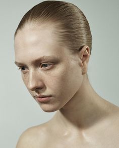 a woman with freckled hair and no shirt on is looking at the camera