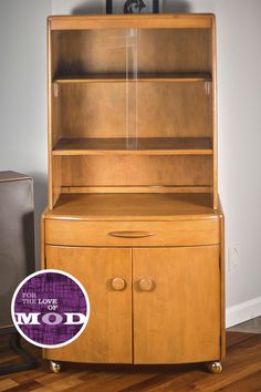 a wooden cabinet with glass doors on the top and bottom, next to a speaker