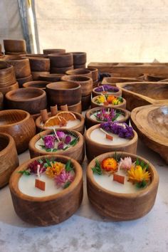 several wooden bowls with flowers in them sitting on a table