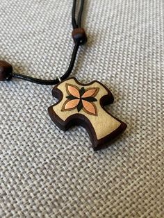 a wooden cross on a black cord necklace