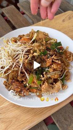 a white plate topped with meat and veggies on top of a wooden table