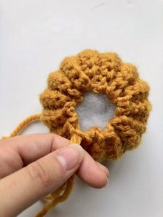 someone is crocheting an object with yarn on the side and holding it in their hand