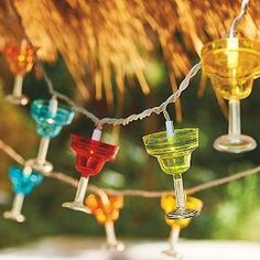 colorful wine glasses are hanging from a string