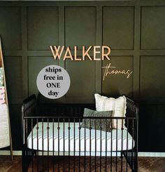 a black metal crib sitting in front of a wall with the word walker on it