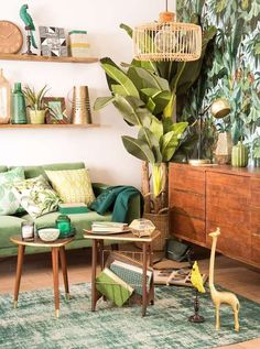 a living room with green furniture and plants on the wall, in an instagramture