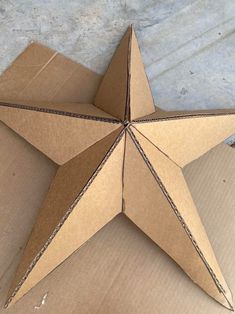 an origami star sitting on top of cardboard in the shape of a box