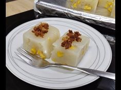 two pieces of cake on a white plate with a fork next to it and tin foil in the background