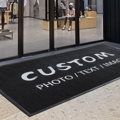 a custom photo and text mat on the ground in front of a store window with mannequins