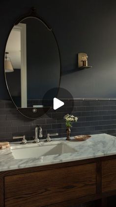 a bathroom sink with a mirror above it and a vase on the counter in front of it