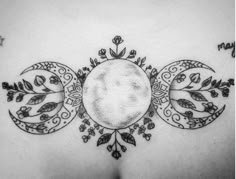 the back of a woman's stomach with three circles and leaves on it, in black and white