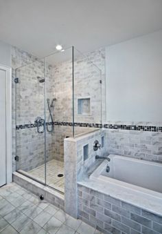 a bathroom with a walk in shower next to a bath tub