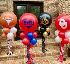 some balloons that are in the shape of basketballs and other sports related items on display