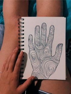 a person holding a notebook with a drawing on it