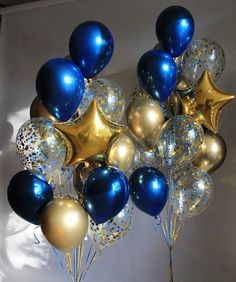 a bunch of blue and gold balloons are in the air