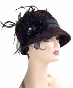 THE GRACE, handmade in Seattle, WA, USA, is a soft and flexible, 1920s style cloche hat. This hat is shown in Bongo Black/Gray Upholstery Fabric with assorted bands and trims. The brim is 2" at center front, flaring out to 2 3/4" at side front, and curving back to 3/4" at center back of hat. The crown is made of six panels. Prices are as shown. May be ordered without band for $79. These hats are custom made and all sales are final. Available in Medium 22-1/2 " and Large 23-1/2 " with custom sizi Gatsby Style Wide Brim Adjustable Hats, Adjustable Wide Brim Flapper Hat, Adjustable Cloche Hat In Flapper Style, Adjustable Cloche Flapper Hat, Gatsby Style Short Brim Cloche Hat For Party, Gatsby Style Cloche Hat With Short Brim For Party, Gatsby Style Party Cloche Hat With Short Brim, Fitted Flapper Cloche Hat With Brim, Flapper Style Short Brim Cloche Hat For Kentucky Derby