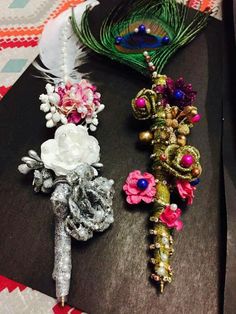 three different types of brooches are laying on a piece of cloth with feathers