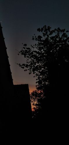 the sun is setting over some buildings and trees