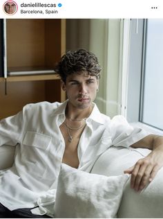 a shirtless man sitting on a white couch