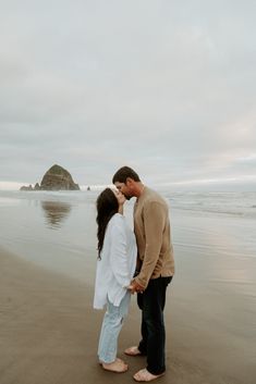 a man and woman kissing on the beach