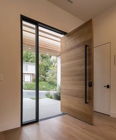 an empty room with wooden flooring and sliding glass doors that lead to the outside