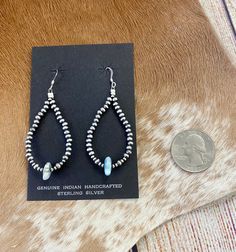 Bring a pop of uplifting color to your wardrobe with these stunning Dry Creek Turquoise earrings! Crafted with lightweight sterling silver, these teardrop earrings are the perfect summer accessory. The Navajo pearl accents add a unique touch of beauty and which makes the Dry Creek Turquoise Earrings truly stand out. Add a pair of Dry Creek Turquoise Earrings to your jewelry collection today! Size: 2 1/4" inches in length Stone: Dry Creek Turquoise with Navajo Pearl accent Metal: Sterling Silver Bohemian Teardrop Pearl Drop Beaded Earrings, Turquoise Teardrop Earrings, Artisan Hypoallergenic Teardrop Earrings, Artisan Teardrop Hypoallergenic Earrings, Hypoallergenic Silver Teardrop Beaded Earrings, Bohemian Teardrop Pearl Drop Earrings, Sterling Silver Teardrop Beaded Earrings With Ear Wire, Sterling Silver Teardrop Beaded Earrings, Bohemian Sterling Silver Teardrop Beaded Earrings