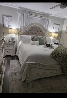 a large white bed sitting in a bedroom next to two lamps