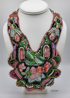 a necklace made out of beads and stones on a mannequin's head