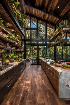 an open kitchen with wooden floors and lots of greenery on the shelves above it