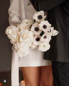 the bride and groom are holding their bouquets in front of eachother's legs