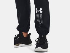 a person wearing black sweatpants with white under - the - knee logo on them