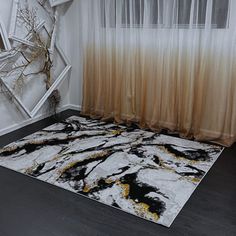 a black and white area rug in front of a window with sheer curtains on it